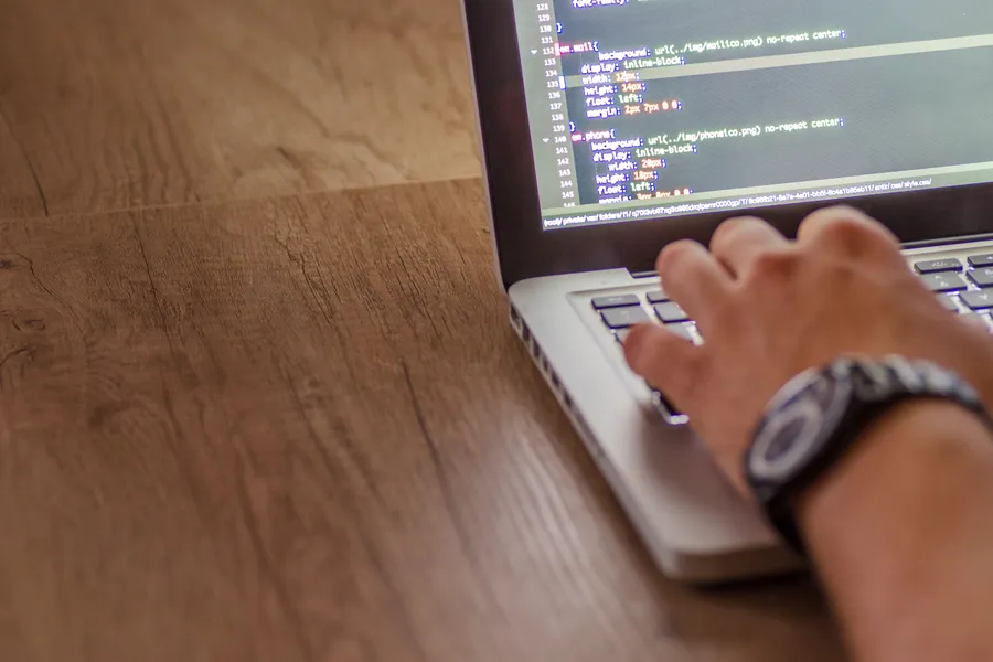 A developer working on code on a laptop